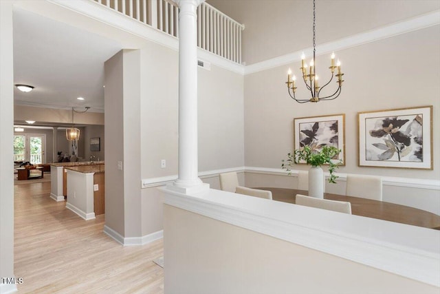 4724 Ludwell Branch Ct, Raleigh, NC 27612 - hall with light wood-style floors, ornate columns, baseboards, and a chandelier