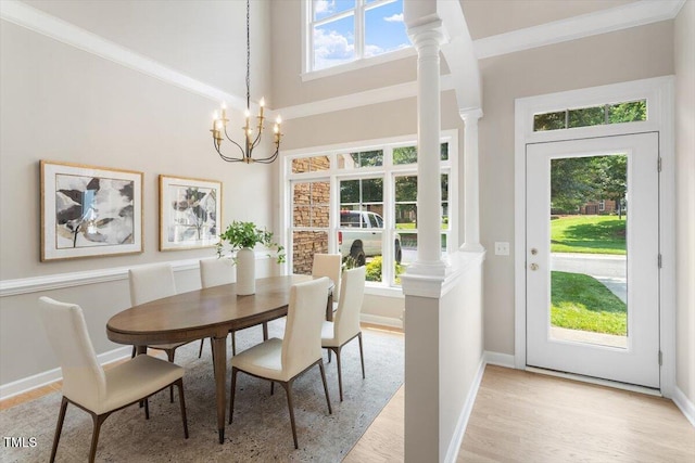 4724 Ludwell Branch Ct, Raleigh, NC 27612 - dining room with light wood-style floors, a chandelier, baseboards, decorative columns, and a high ceiling