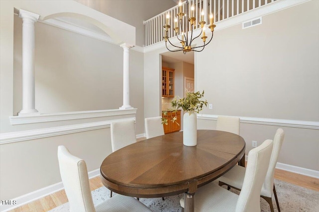 4724 Ludwell Branch Ct, Raleigh, NC 27612 - dining space with light wood-style floors, a chandelier, a high ceiling, and baseboards