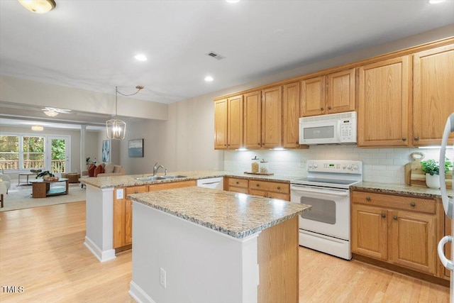 4724 Ludwell Branch Ct, Raleigh, NC 27612 - kitchen with white appliances, a sink, a peninsula, light wood-style floors, and recessed lighting