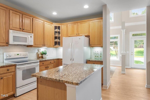4724 Ludwell Branch Ct, Raleigh, NC 27612 - kitchen with white appliances, light stone counters, light wood-type flooring, ornate columns, and glass insert cabinets