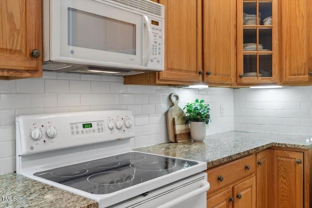 4724 Ludwell Branch Ct, Raleigh, NC 27612 - kitchen with white appliances, brown cabinetry, and glass insert cabinets