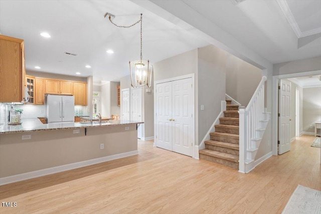 4724 Ludwell Branch Ct, Raleigh, NC 27612 - kitchen with freestanding refrigerator, ornamental molding, light wood-type flooring, glass insert cabinets, and light stone countertops