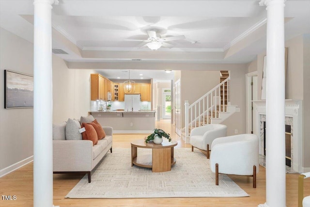 4724 Ludwell Branch Ct, Raleigh, NC 27612 - living room featuring ornate columns, a ceiling fan, crown molding, and light wood-style floors