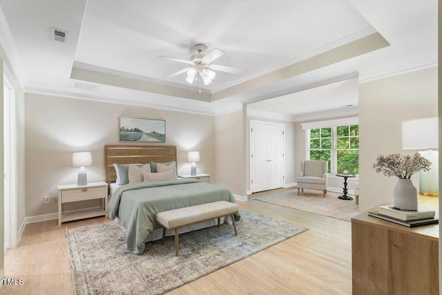 4724 Ludwell Branch Ct, Raleigh, NC 27612 - bedroom featuring a tray ceiling, ornamental molding, baseboards, light wood-style floors, and ceiling fan