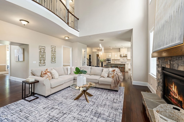 7632 Summer Pines Way, Wake Forest, NC 27587 - living room featuring a towering ceiling, dark wood-type flooring, and a stone fireplace