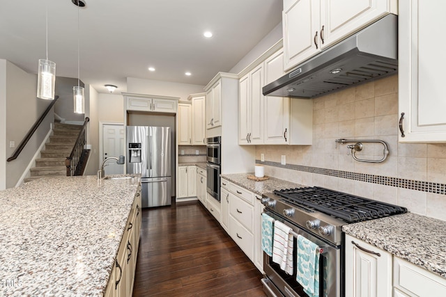 7632 Summer Pines Way, Wake Forest, NC 27587 - kitchen with stainless steel appliances, under cabinet range hood, tasteful backsplash, light stone counters, and recessed lighting