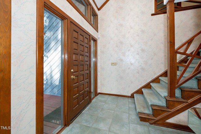403 Rutherglen Dr, Cary, NC 27511 - entrance foyer with wallpapered walls, stairs, baseboards, and light tile patterned floors