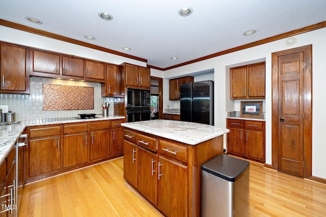 403 Rutherglen Dr, Cary, NC 27511 - kitchen with black appliances, crown molding, light wood-style floors, a center island, and backsplash