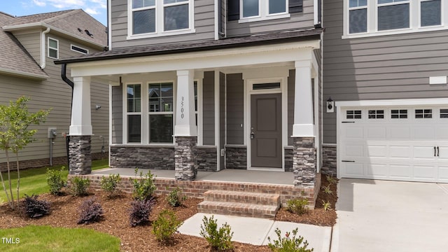 3500 Bailey Lake Dr, Fuquay Varina, NC 27526 - view of exterior entry with a porch, an attached garage, stone siding, and driveway
