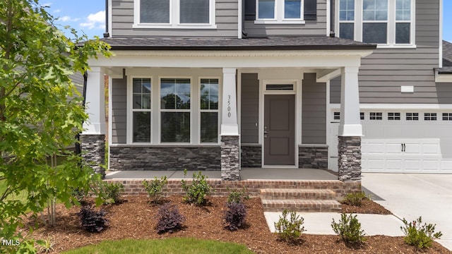 3500 Bailey Lake Dr, Fuquay Varina, NC 27526 - doorway to property featuring an attached garage, stone siding, covered porch, and driveway