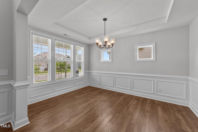 3500 Bailey Lake Dr, Fuquay Varina, NC 27526 - unfurnished dining area with a tray ceiling, a chandelier, dark wood-type flooring, a wainscoted wall, and a decorative wall