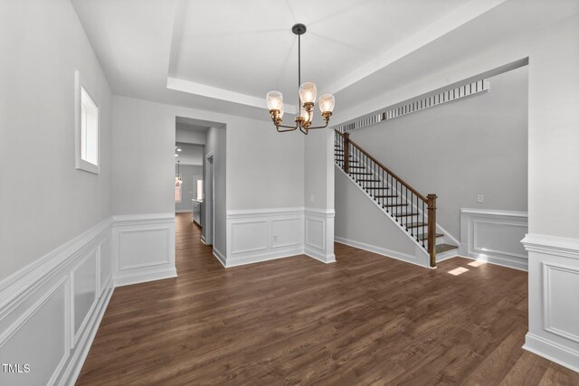 3500 Bailey Lake Dr, Fuquay Varina, NC 27526 - unfurnished dining area featuring a chandelier, stairs, dark wood-style flooring, a tray ceiling, and a decorative wall