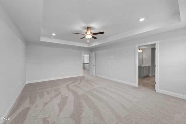 3500 Bailey Lake Dr, Fuquay Varina, NC 27526 - unfurnished bedroom with a tray ceiling, light carpet, recessed lighting, connected bathroom, and a ceiling fan