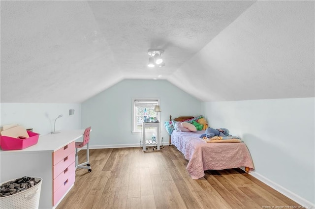 239 Rainier Dr, Fayetteville, NC 28314 - bedroom with light wood-style flooring, a textured ceiling, vaulted ceiling, a desk, and baseboards