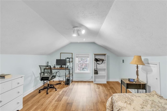 239 Rainier Dr, Fayetteville, NC 28314 - bedroom with light wood finished floors, a textured ceiling, baseboards, vaulted ceiling, and a desk