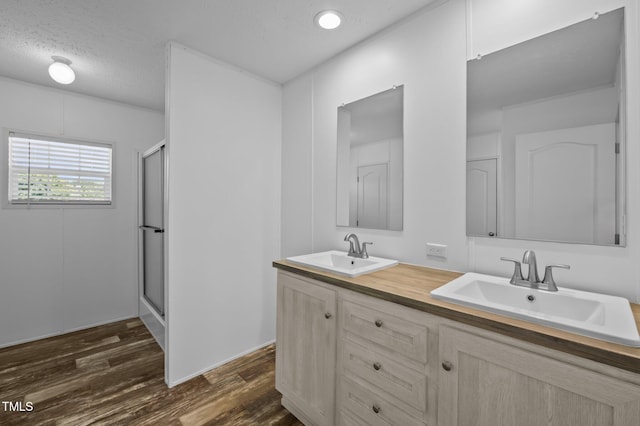 130 Ruby Trl, Roxboro, NC 27574 - full bathroom featuring double vanity, a shower stall, wood finished floors, and a textured ceiling