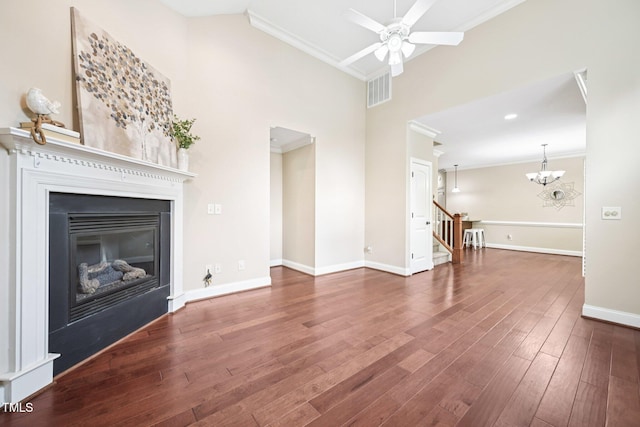 1090 Indigo Ridge Pl, Cary, NC 27519 - unfurnished living room featuring ornamental molding, a ceiling fan, a glass covered fireplace, stairway, and wood finished floors