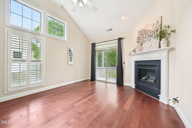 1090 Indigo Ridge Pl, Cary, NC 27519 - unfurnished living room featuring high vaulted ceiling, wood finished floors, a ceiling fan, and a glass covered fireplace