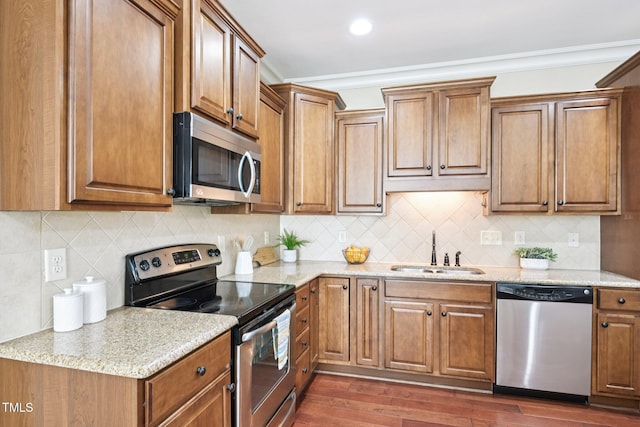 1090 Indigo Ridge Pl, Cary, NC 27519 - kitchen with stainless steel appliances, dark wood finished floors, brown cabinetry, tasteful backsplash, and light stone countertops
