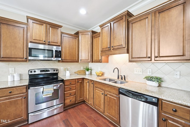 1090 Indigo Ridge Pl, Cary, NC 27519 - kitchen featuring appliances with stainless steel finishes, crown molding, dark wood-style flooring, brown cabinets, and light stone countertops