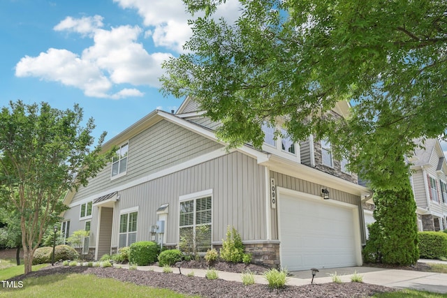 1090 Indigo Ridge Pl, Cary, NC 27519 - view of front of house featuring an attached garage, concrete driveway, stone siding, and board and batten siding