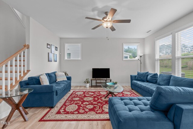 309 Highland Forest Dr, Fuquay Varina, NC 27526 - living room featuring plenty of natural light, stairway, light wood-type flooring, and a ceiling fan