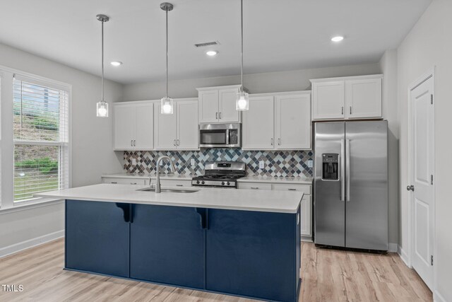 309 Highland Forest Dr, Fuquay Varina, NC 27526 - kitchen with stainless steel appliances, light countertops, a sink, white cabinetry, and recessed lighting