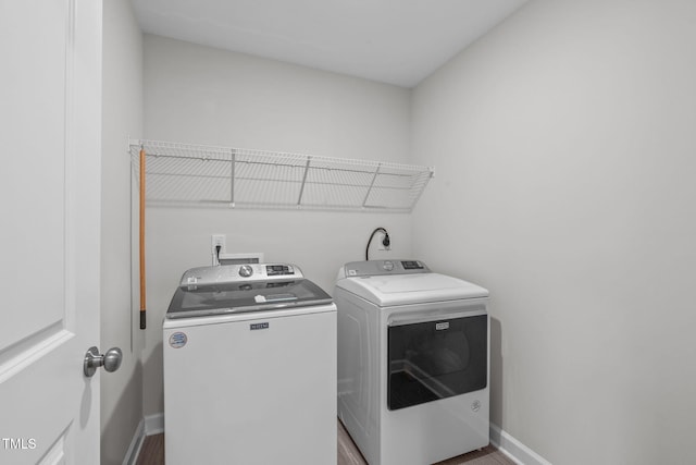 309 Highland Forest Dr, Fuquay Varina, NC 27526 - laundry area featuring washing machine and clothes dryer, baseboards, and wood finished floors