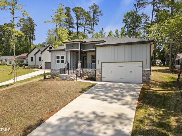 107 Mohave Dr, Louisburg, NC 27549 - view of front of house featuring board and batten siding, a garage, driveway, a shingled roof, and a porch
