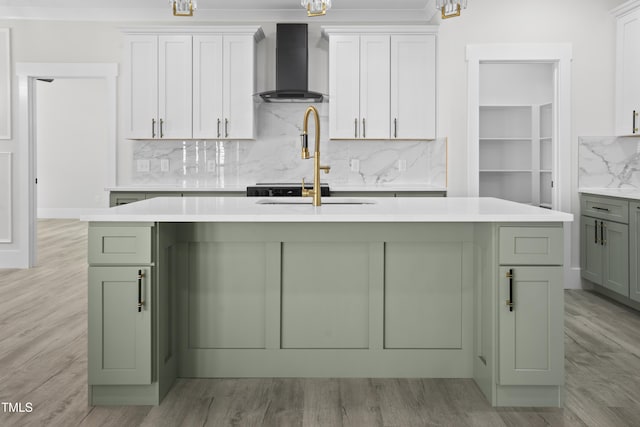 107 Mohave Dr, Louisburg, NC 27549 - kitchen featuring wall chimney exhaust hood, green cabinets, light countertops, decorative backsplash, and light wood-type flooring