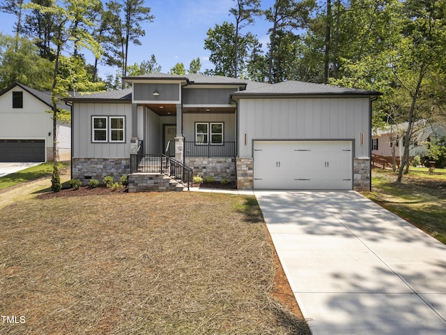 107 Mohave Dr, Louisburg, NC 27549 - view of front of home featuring an attached garage, stone siding, concrete driveway, and board and batten siding