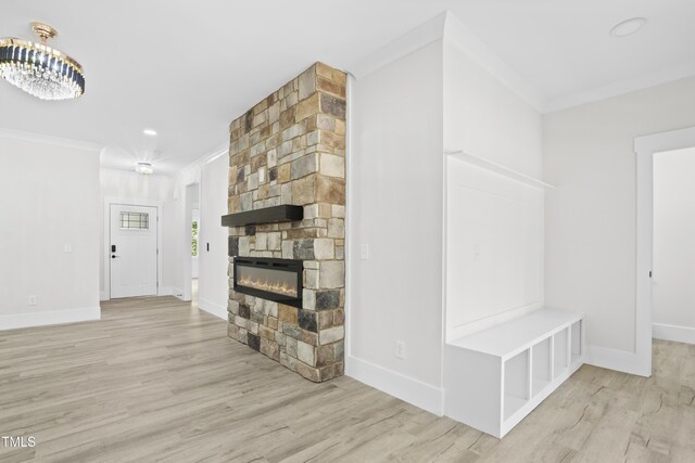 107 Mohave Dr, Louisburg, NC 27549 - unfurnished living room featuring crown molding, light wood-style floors, a fireplace, baseboards, and a chandelier