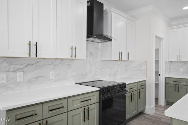 107 Mohave Dr, Louisburg, NC 27549 - kitchen featuring wall chimney exhaust hood, black / electric stove, green cabinetry, light countertops, and ornamental molding