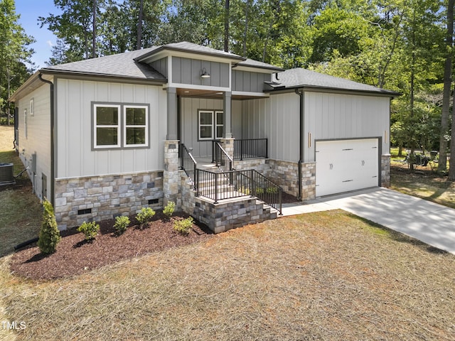 107 Mohave Dr, Louisburg, NC 27549 - view of front facade featuring stone siding, concrete driveway, an attached garage, and board and batten siding