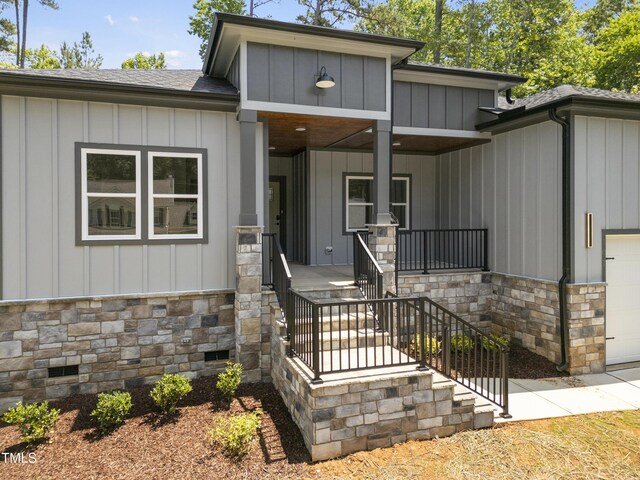 107 Mohave Dr, Louisburg, NC 27549 - view of front of property with stone siding, board and batten siding, covered porch, and roof with shingles