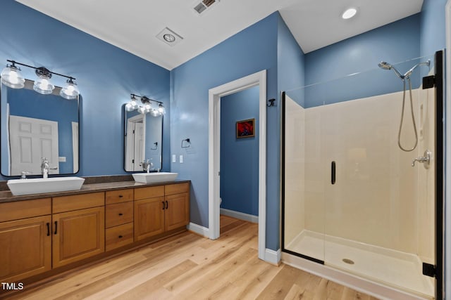 4511 Crab Creek Dr Unit 101, Raleigh, NC 27612 - full bathroom with a shower stall, double vanity, and wood finished floors
