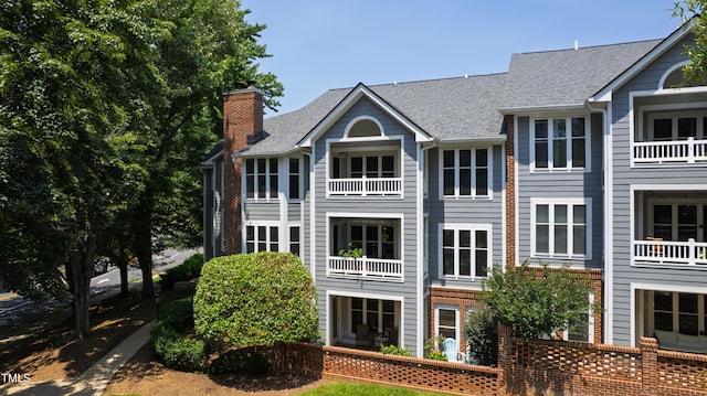 911 Washington St Unit 304, Raleigh, NC 27605 - rear view of property featuring a chimney and a shingled roof
