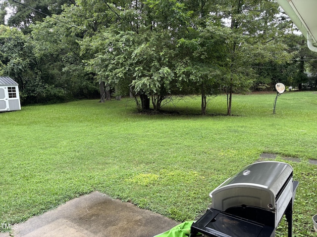 301 Roseland Ave, Durham, NC 27712 - view of grassy yard featuring a storage unit and view of wooded area