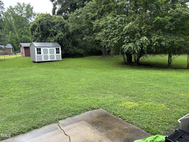 301 Roseland Ave, Durham, NC 27712 - view of grassy yard featuring a storage unit and view of wooded area