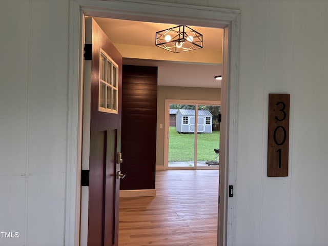 301 Roseland Ave, Durham, NC 27712 - corridor with light wood finished floors and a chandelier