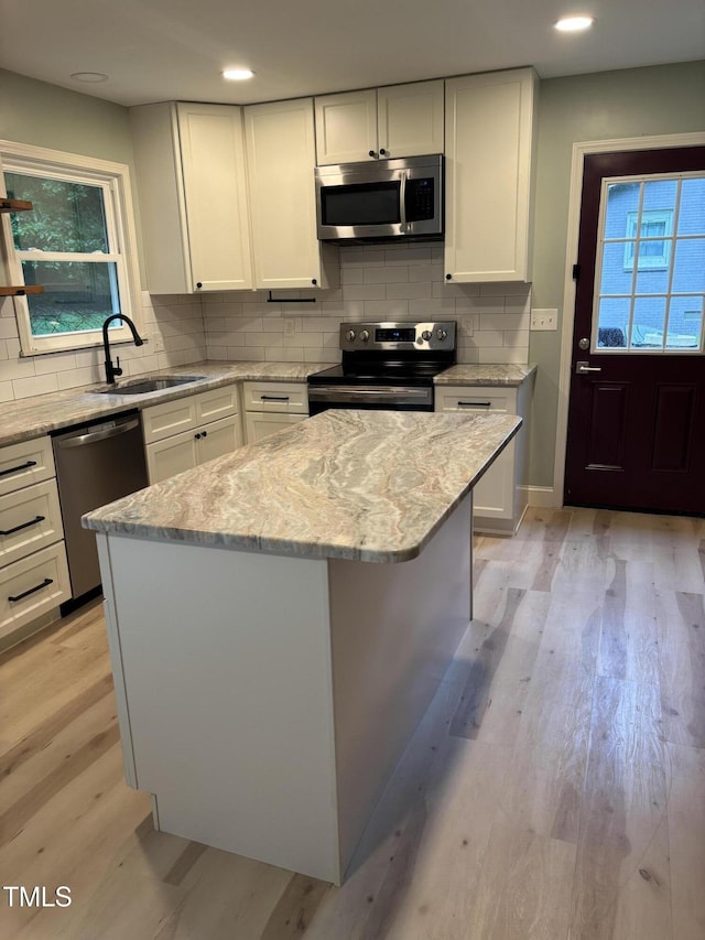 301 Roseland Ave, Durham, NC 27712 - kitchen featuring appliances with stainless steel finishes, decorative backsplash, light stone counters, white cabinets, and recessed lighting