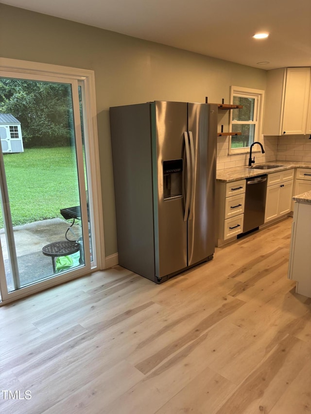 301 Roseland Ave, Durham, NC 27712 - kitchen featuring appliances with stainless steel finishes, light wood finished floors, decorative backsplash, white cabinets, and recessed lighting