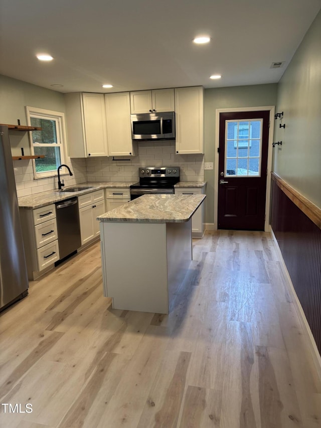 301 Roseland Ave, Durham, NC 27712 - kitchen with appliances with stainless steel finishes, light wood-style floors, light stone countertops, white cabinets, and recessed lighting