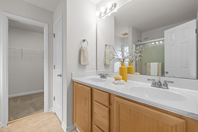508 Hidden Cellars Dr, Holly Springs, NC 27540 - bathroom featuring a shower stall, double vanity, a textured ceiling, tile patterned flooring, and a spacious closet