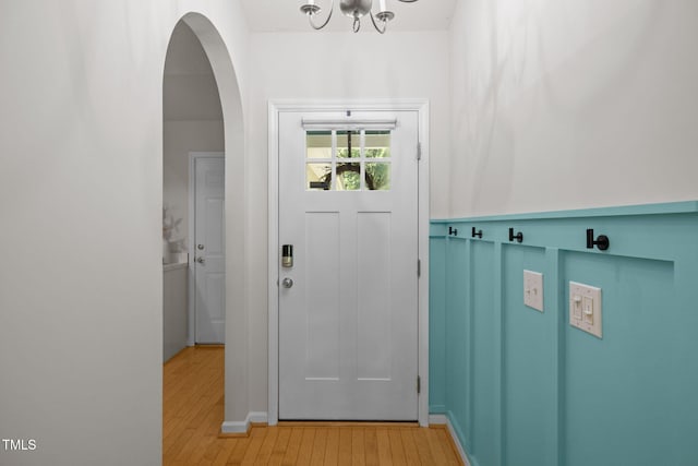508 Hidden Cellars Dr, Holly Springs, NC 27540 - doorway to outside featuring light wood finished floors, a chandelier, and arched walkways