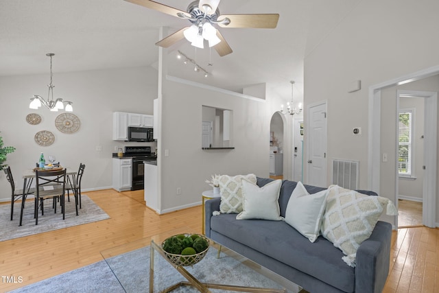 508 Hidden Cellars Dr, Holly Springs, NC 27540 - living area featuring a chandelier, high vaulted ceiling, arched walkways, light wood-style flooring, and ceiling fan