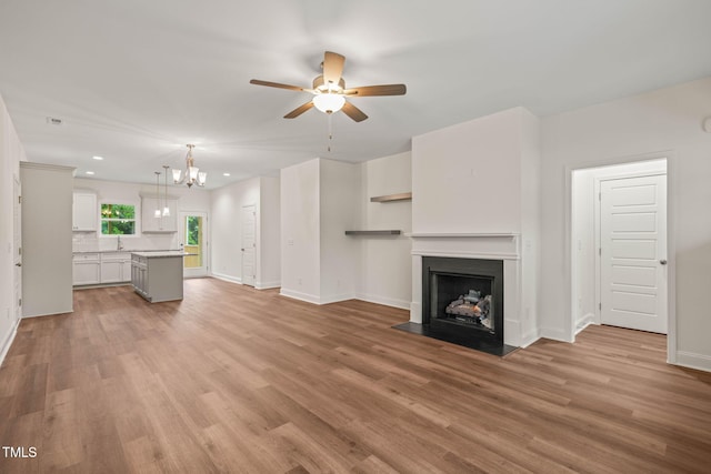 156 Harmony Trl, Broadway, NC 27505 - unfurnished living room featuring a sink, ceiling fan, a chandelier, baseboards, and recessed lighting
