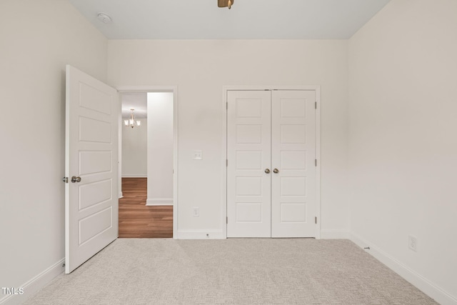 156 Harmony Trl, Broadway, NC 27505 - unfurnished bedroom with carpet, a closet, baseboards, and a chandelier