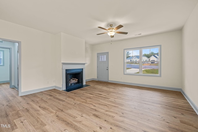 147 Harmony Trl, Broadway, NC 27505 - unfurnished living room featuring healthy amount of natural light, light wood-type flooring, a ceiling fan, and a fireplace with flush hearth